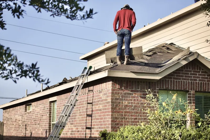 Professional roofer working on a residential roof in Folwell